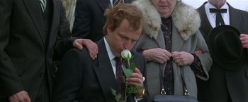 Movie still from “The People vs. Larry Flynt” (1996), directed by Milos Forman – A man in a suit smelling a white rose; Close Up shot, Over the shoulder angle