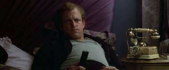 Movie still from “The People vs. Larry Flynt” (1996), directed by Milos Forman – A man sitting in a chair holding a remote control; Close Up shot, Low angle