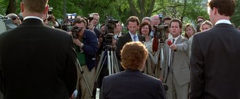 Movie still from “The People vs. Larry Flynt” (1996), directed by Milos Forman – A group of people standing around a man in a suit; Medium shot, Over the shoulder angle