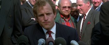 Movie still from “The People vs. Larry Flynt” (1996), directed by Milos Forman – A man in a suit and red neck tie is speaking; Close Up shot, Over the shoulder angle