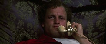 Movie still from “The People vs. Larry Flynt” (1996), directed by Milos Forman – A man is talking on a phone while laying down; Close Up shot, Low angle