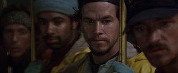 Movie still from “The Perfect Storm” (2000), directed by Wolfgang Petersen – A man with a beard is standing next to another man with a beard; Close Up shot, Low angle