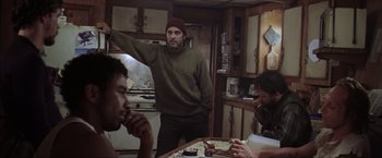 Movie still from “The Perfect Storm” (2000), directed by Wolfgang Petersen – A group of people sitting at a table in a room; Medium shot, Over the shoulder angle