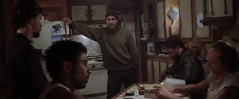 Movie still from “The Perfect Storm” (2000), directed by Wolfgang Petersen – A group of people sitting at a table in a room; Medium shot, Low angle