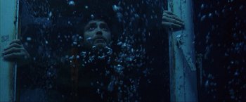 Movie still from “The Perfect Storm” (2000), directed by Wolfgang Petersen – A man in the water looking up at the sky; Close Up shot, Low angle