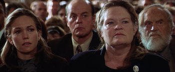 Movie still from “The Perfect Storm” (2000), directed by Wolfgang Petersen – A group of people sitting next to each other in a room; Close Up shot, Over the shoulder angle