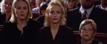 Movie still from “The Perfect Storm” (2000), directed by Wolfgang Petersen – A woman sitting in front of a group of people; Close Up shot, High angle