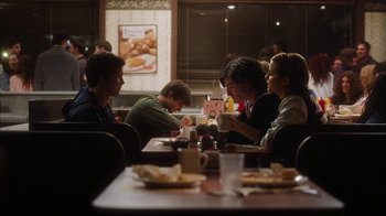 Movie still from “The Perks of Being a Wallflower” (2012), directed by Stephen Chbosky – A group of people sitting at a table in a restaurant; Medium shot, Over the shoulder angle