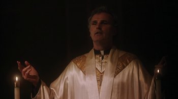 Movie still from “The Perks of Being a Wallflower” (2012), directed by Stephen Chbosky – A man wearing a priest's outfit in the dark; Close Up shot, Low angle