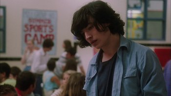 Movie still from “The Perks of Being a Wallflower” (2012), directed by Stephen Chbosky – A man with long hair and a blue shirt is in a room; Medium shot, Over the shoulder angle