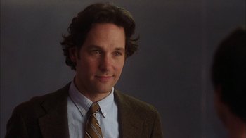 Movie still from “The Perks of Being a Wallflower” (2012), directed by Stephen Chbosky – A man in a suit and tie smiling for the camera; Close Up shot, Over the shoulder angle