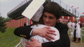 Movie still from “The Perks of Being a Wallflower” (2012), directed by Stephen Chbosky – A man and a woman hugging each other in graduation attire; Close Up shot, Over the shoulder angle