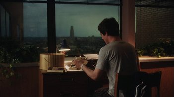 Movie still from “The Perks of Being a Wallflower” (2012), directed by Stephen Chbosky – A man sitting in front of a window at a desk; Wide shot, High angle