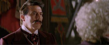 Movie still from “The Phantom of the Opera” (2004), directed by Joel Schumacher – A person wearing a suit and tie; Close Up shot, Low angle