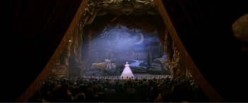 Movie still from “The Phantom of the Opera” (2004), directed by Joel Schumacher – A woman in a white dress on a stage; Wide shot, High angle