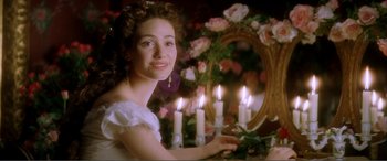 Movie still from “The Phantom of the Opera” (2004), directed by Joel Schumacher – A beautiful young lady sitting in front of a mirror with lit candles; Close Up shot, Over the shoulder angle