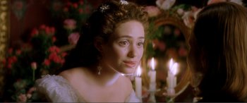 Movie still from “The Phantom of the Opera” (2004), directed by Joel Schumacher – A woman in a white dress with candles in the background; Close Up shot, Over the shoulder angle