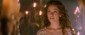 Movie still from “The Phantom of the Opera” (2004), directed by Joel Schumacher – A beautiful young woman with long brown curly hair wearing a white dress; Close Up shot, Over the shoulder angle