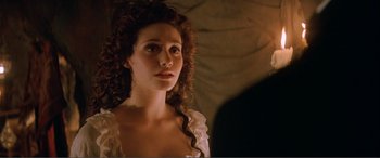 Movie still from “The Phantom of the Opera” (2004), directed by Joel Schumacher – A woman in a white dress looking to her left; Close Up shot, Over the shoulder angle