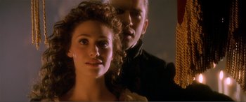 Movie still from “The Phantom of the Opera” (2004), directed by Joel Schumacher – A man and a woman standing next to each other; Close Up shot, Over the shoulder angle