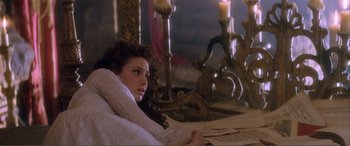 Movie still from “The Phantom of the Opera” (2004), directed by Joel Schumacher – A beautiful young lady sitting on top of a bed; Medium shot, High angle