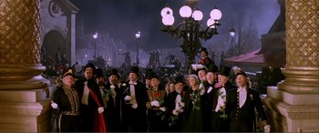 Movie still from “The Phantom of the Opera” (2004), directed by Joel Schumacher – A group of people dressed in black and wearing hats and holding white roses; Extreme Wide shot, High angle