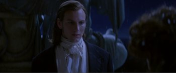 Movie still from “The Phantom of the Opera” (2004), directed by Joel Schumacher – A man with long hair wearing a black suit and a white shirt; Close Up shot, Low angle