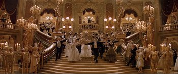Movie still from “The Phantom of the Opera” (2004), directed by Joel Schumacher – A group of people in formal wear standing on a staircase; Extreme Wide shot, Low angle