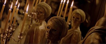 Movie still from “The Phantom of the Opera” (2004), directed by Joel Schumacher – View of a group of statues with lit candles; Close Up shot, High angle