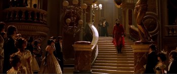 Movie still from “The Phantom of the Opera” (2004), directed by Joel Schumacher – A group of people standing around a staircase; Wide shot, High angle