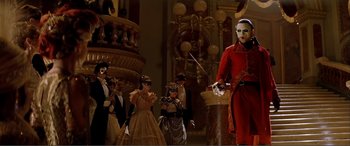Movie still from “The Phantom of the Opera” (2004), directed by Joel Schumacher – A group of people dressed up in costumes and masks; Wide shot, Low angle