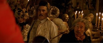 Movie still from “The Phantom of the Opera” (2004), directed by Joel Schumacher – A man in a costume with horns on his head; Close Up shot, Over the shoulder angle