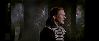 Movie still from “The Phantom of the Opera” (2004), directed by Joel Schumacher – A man in a military uniform looking to his left; Medium shot, Over the shoulder angle
