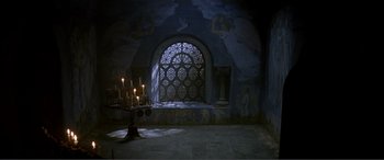 Movie still from “The Phantom of the Opera” (2004), directed by Joel Schumacher – Candles lit in a room with an ornate window; Extreme Wide shot, High angle