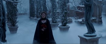 Movie still from “The Phantom of the Opera” (2004), directed by Joel Schumacher – A woman in a black dress holding a bouquet of roses; Wide shot, Over the shoulder angle