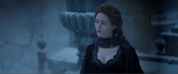 Movie still from “The Phantom of the Opera” (2004), directed by Joel Schumacher – A woman in a black dress standing next to a fountain; Close Up shot, Over the shoulder angle