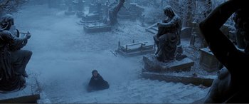 Movie still from “The Phantom of the Opera” (2004), directed by Joel Schumacher – A woman sitting on the ground in the snow; Wide shot, High angle