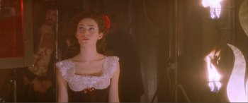 Movie still from “The Phantom of the Opera” (2004), directed by Joel Schumacher – A young woman wearing a white dress with red flowers in her hair; Close Up shot, Low angle
