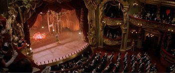 Movie still from “The Phantom of the Opera” (2004), directed by Joel Schumacher – An audience is sitting in a theater with a large stage; Extreme Wide shot, High angle