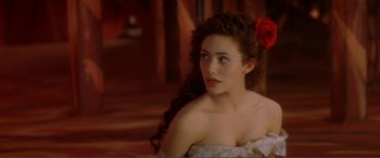 Movie still from “The Phantom of the Opera” (2004), directed by Joel Schumacher – A beautiful young woman with a red flower in her hair; Close Up shot, Over the shoulder angle