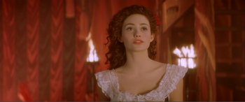 Movie still from “The Phantom of the Opera” (2004), directed by Joel Schumacher – A young woman with long curly hair wearing a white dress; Close Up shot, Over the shoulder angle