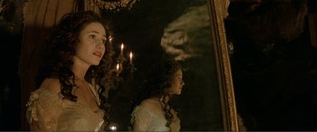 Movie still from “The Phantom of the Opera” (2004), directed by Joel Schumacher – A woman standing in front of a mirror with candles; Close Up shot, Over the shoulder angle