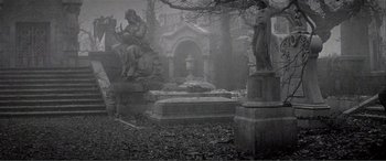 Movie still from “The Phantom of the Opera” (2004), directed by Joel Schumacher – An image of an old graveyard with a statue in the foreground; Wide shot, Low angle