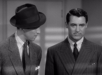 Movie still from “The Philadelphia Story” (1940), directed by George Cukor – A man in a suit and a man in a hat; Medium shot, Over the shoulder angle