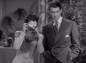 Movie still from “The Philadelphia Story” (1940), directed by George Cukor – A man and a woman taking a picture with a camera; Medium shot, Low angle