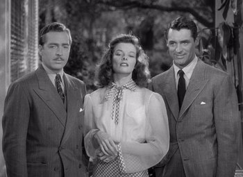 Movie still from “The Philadelphia Story” (1940), directed by George Cukor – A woman standing between two men wearing suits; Medium shot, Low angle