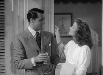 Movie still from “The Philadelphia Story” (1940), directed by George Cukor – A man and a woman standing next to each other holding drinks; Medium shot, Over the shoulder angle