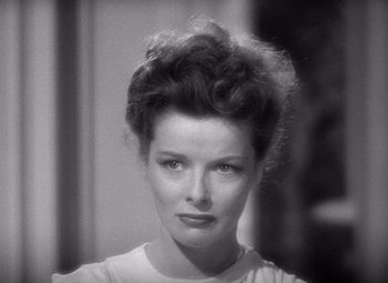 Movie still from “The Philadelphia Story” (1940), directed by George Cukor – A black - and - white photo of a woman in a white shirt; Close Up shot, High angle