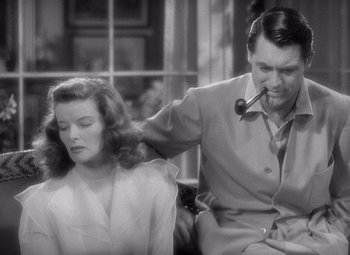 Movie still from “The Philadelphia Story” (1940), directed by George Cukor – An old photo of a man and a woman sitting on a couch; Medium shot, Over the shoulder angle