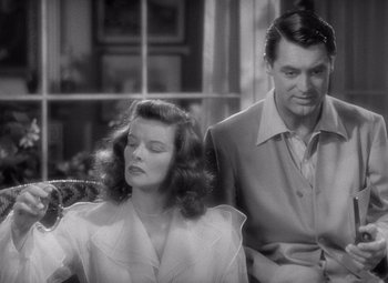 Movie still from “The Philadelphia Story” (1940), directed by George Cukor – A man and a woman sitting next to each other on a bench; Medium shot, Over the shoulder angle